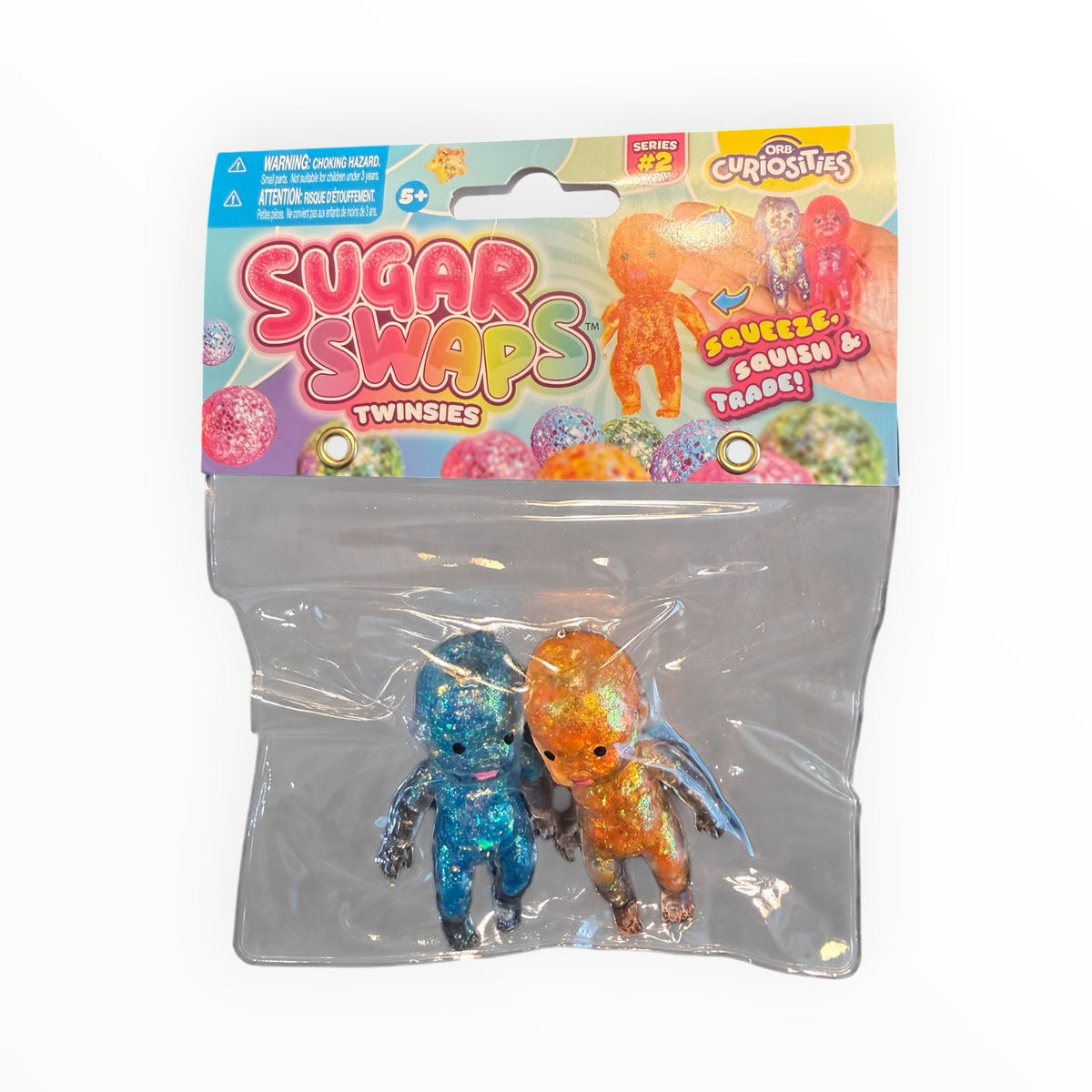 Southern Charm Collectibles Sugar Swaps Twinsies glittery blue and orange squishy baby figures in retail packaging.